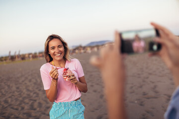 Summer holidays and vacation - girl eating ice cream on the beach