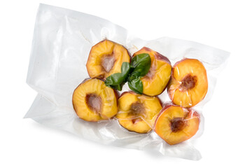 Peaches cut in half with mint leaves in vacuum packed sealed for sous vide cooking isolated on white