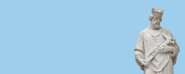 Banner with statue of a priest with figure of crucified Jesus in Vienna downtown at blue sky solid background with copy space, Austria, details, closeup. Concept of historical architecture heritage.