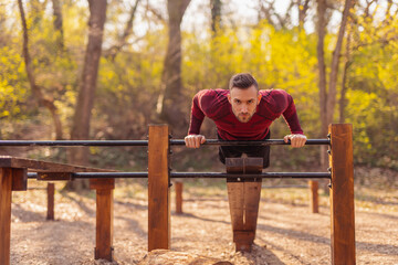 Man working out in street workout park, doing push ups