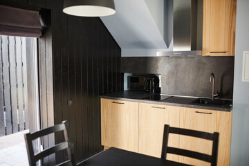 Background image of minimal house interior with focus on wooden kitchen countertops in black color, copy space