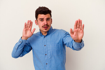 Young caucasian man isolated on white background being shocked due to an imminent danger