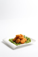deep fried crispy golden scallops or chicken or fish nugget salad in white black  background dim sum snack halal menu