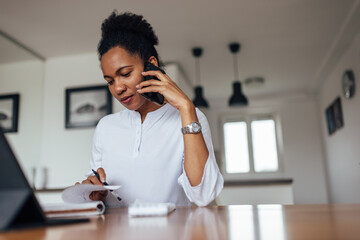 Adult woman, conducting an interview over the phone.