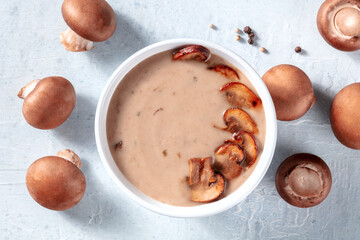 Mushroom cream soup, shot from the top with portobello mushrooms and pepper on a table