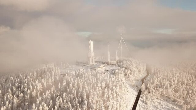 Dlog Drone view of the Feldberg Taunus Schmitten area during a cold winter day. Trees covered in snow and ice. Forrest in snow. Filmed during sunrise. Snow is wonderfully coloured in orange and red.