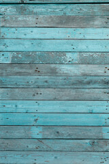 A piece of a wooden wall and a cracked blue paint