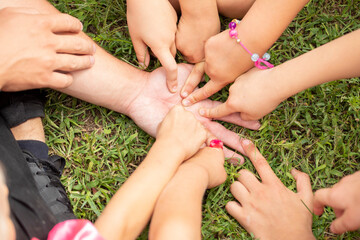 children's hands in a circle are laid on an adult palm a sign of friendship, horizontal,