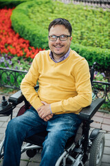Obraz premium a man with disabilities in a wheelchair walking looks at the view