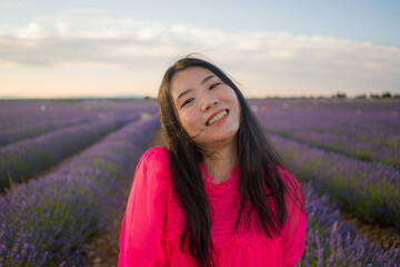 young happy and beautiful Asian Korean woman in Summer dress enjoying nature running free and playful outdoors at purple lavender flowers field in romantic beauty concept