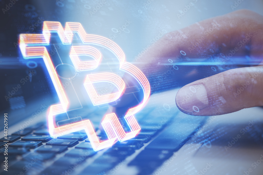 Poster close up of hands using notebook at desktop with creative glowing bitcoin icon on blurry blue backgr