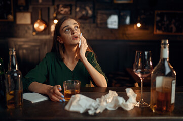 Drunk depressed woman at the counter in bar