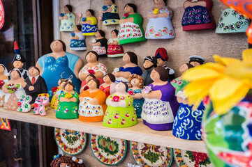 Traditional souvenirs of Otranto, Apulia, Italy. Colorful ceramic figures of women. Gifts from...