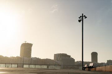 sunset behind buildings near the sea