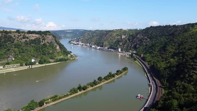 Video from a drone flying above the Rhine river in Germany, visible buildings on the banks of the river and ships.
