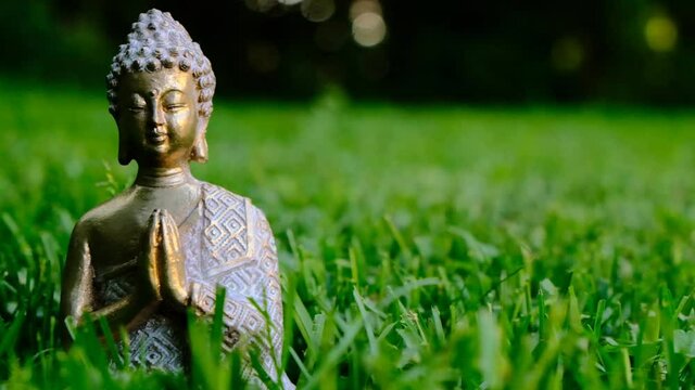 Zen. Buddha statue in the grass on a blurred green garden background. Buddhism symbol. Calm, balance and harmony.
Buddhism religion symbol.Meditation and relaxation ritual.