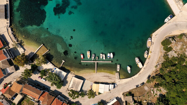 Top down shot of the small turquoise harbor at Frikes in Ithaca with fishing boats moored