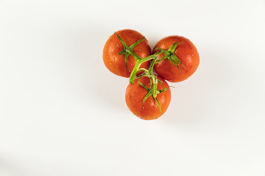 Top View Of Cluster Of Tomatoes With Drops On White Background