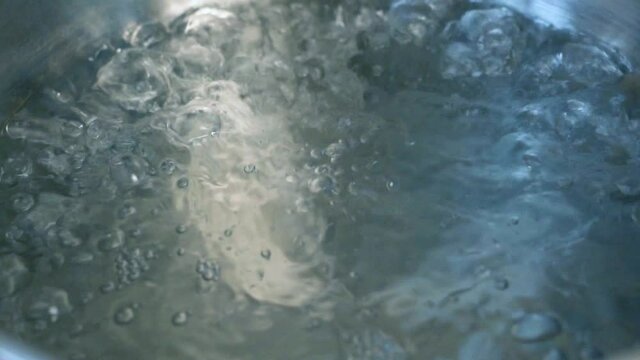 Boiling Water. Water Bubbles at Boiling, Close-up. Water Boils in a Pot, Macro, Slow Motion.