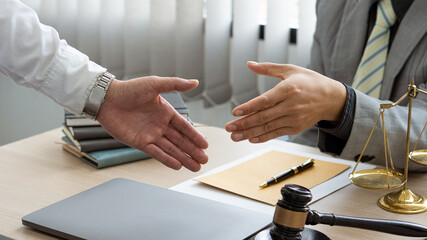Businessman and lawyer discussing contract documents sitting at a table Legal ideas, advice, agreements with a partner attorney or lawyer discussing contractual agreements.