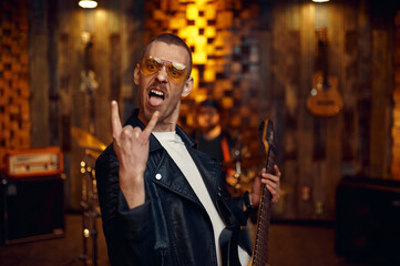 Male musician with electric guitar on stage in bar