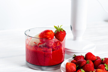 The process of making strawberry mousse, cocktail. Strawberry puree, smoothie in a blender