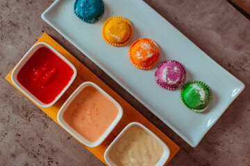 Sorrentinos en plato con salsa de colores y servilletas