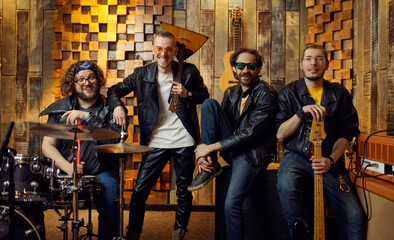 Four brutal artists poses on stage, rock band