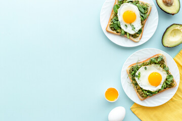 Eggs and avocado with spinach on toasted bread. Top view