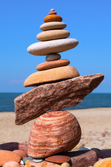 Rock zen pyramid of colorful pebbles on a background of blue sky