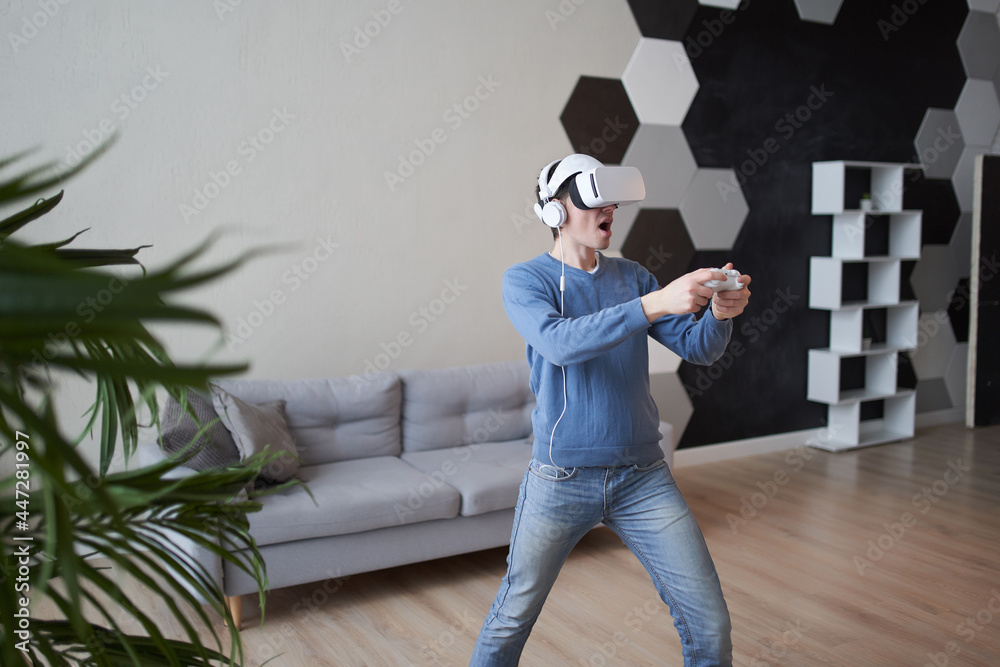 Wall mural man with virtual reality headset is playing game.