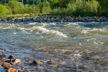 Stormy stream mountain river with rocky bottom close-up. Foamed water from fast flow. Nature Ukraine outdoor, Carpathian mountains