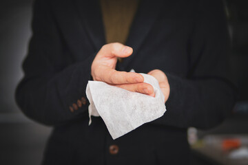 Man cleaning hands with antibacterial sanitary napkin after working preventing virus and bacteria spreading. businessman disinfects his hands after shaking hands