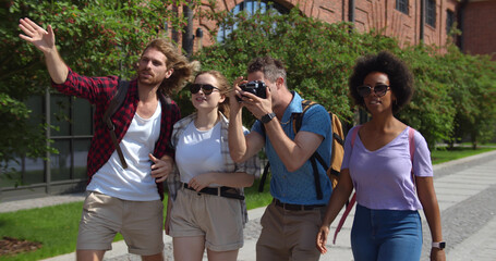 Happy group of multiethnic tourists enjoying sightseeing together in european city