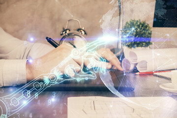 Double exposure of man's hands holding and using a digital device and tech theme hologram drawing. Technology concept.