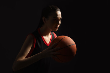 Basketball player with ball on black background