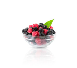 raspberries and blackberries in a transparent bowl isolated on a white background
