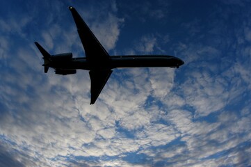 Airliner on final approach in cloudy autumn twilight sky