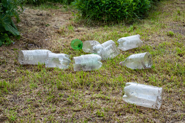 Plastic bottles. Heap of used cut old dirty plastic bottles on dry grass. Environmental pollution concept. Ecological problem. Recycling of plastic waste. Selective focus.
