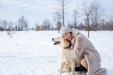 Fototapeta na wymiar Young beautiful woman and her golden retriever dog having fun in winter.