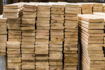 A board made of larch in a stack. Construction industry. For construction and finishing works. Sale of construction materials.