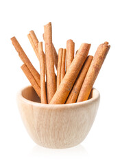 Cinnamon sticks in wooden bowl isolated on white background.