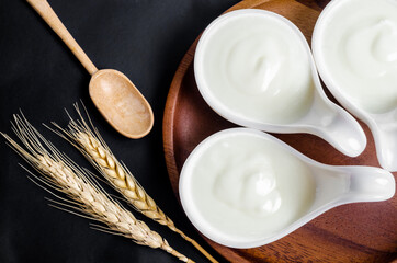 Greek yogurt in a white cup and dry barley.