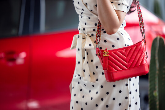 July 26, 2021: Nakhon Prathom, THAILAND, A woman holding a red Chanel square bag is a high-end fashion house that specializes in leather goods.