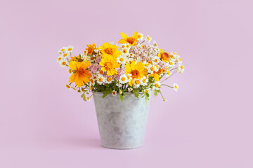 Beautiful summer flowers in a vintage pot on a pink background.