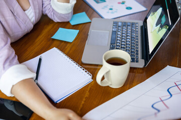 Young woman, manager working at office. Using laptop, modern gadgets. Remote working. Workplace at company, home with PC, devices.