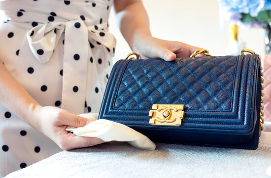 July 26, 2021: Nakhon Prathom, THAILAND, On the table, a woman cleans a black Chanel purse.
