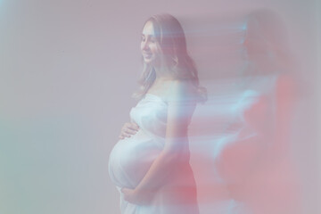 Elegant pregnant young woman standing wearing light fabric. Pregnancy, fantasy and fairy tale concept.