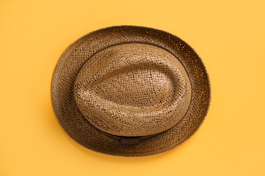 Stylish straw hat on orange background, top view
