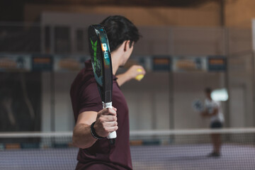 a boy paddle player ready to throw a ball.